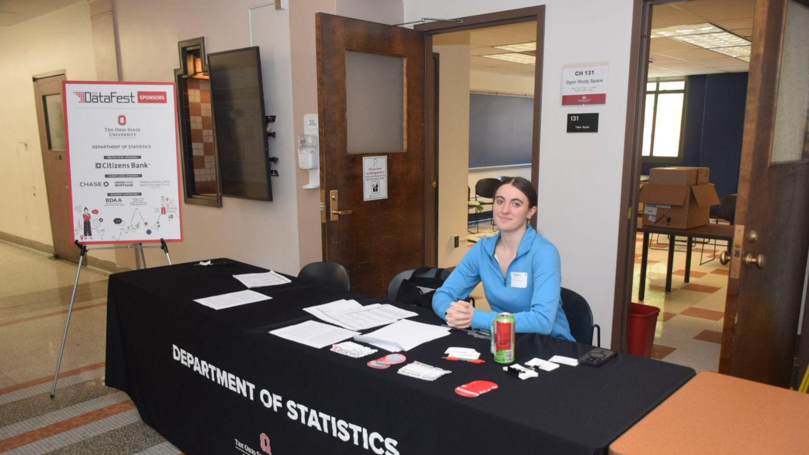 Student sitting at DataFest registration desk.