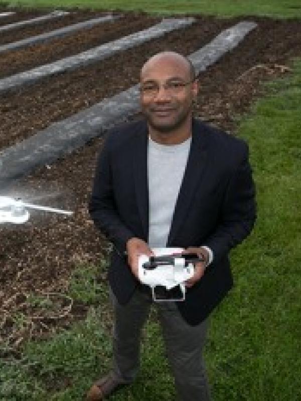 Chris Stewart operating a small drone out in a field
